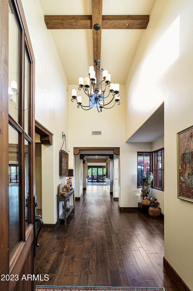 foyer entrance featuring beamed ceiling, dark hardwood / wood-style floors, a chandelier, and high vaulted ceiling