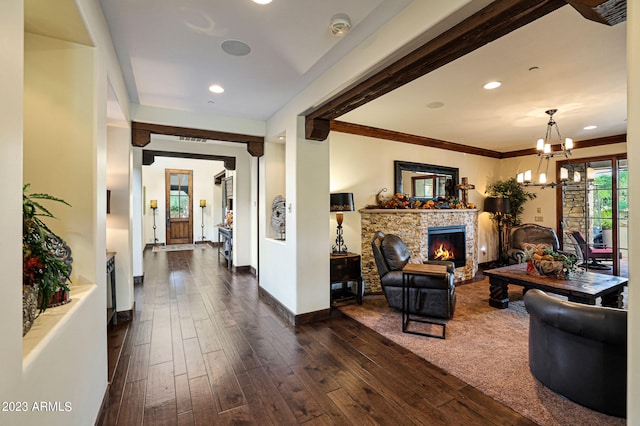 living room with an inviting chandelier, dark hardwood / wood-style floors, a fireplace, and crown molding