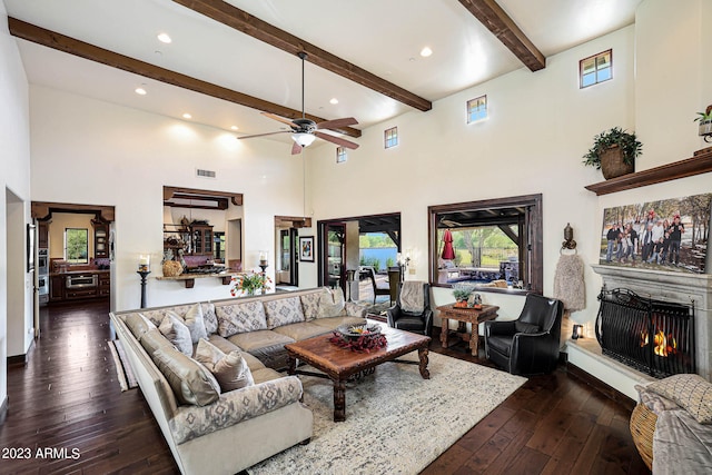 living room with beamed ceiling, a towering ceiling, dark hardwood / wood-style floors, and ceiling fan