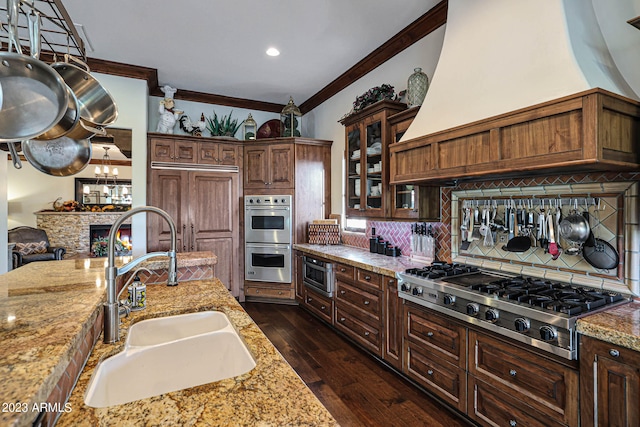 kitchen with light stone countertops, sink, appliances with stainless steel finishes, and dark hardwood / wood-style flooring