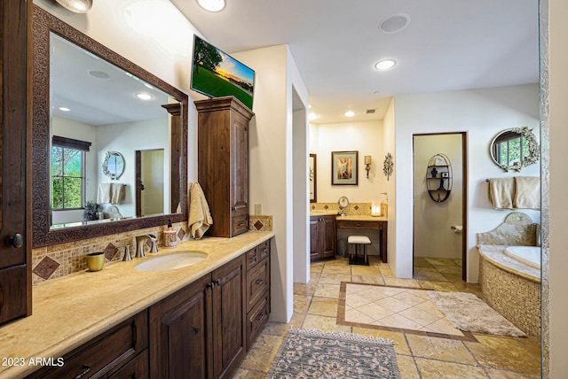 bathroom with a washtub, vanity, and tasteful backsplash