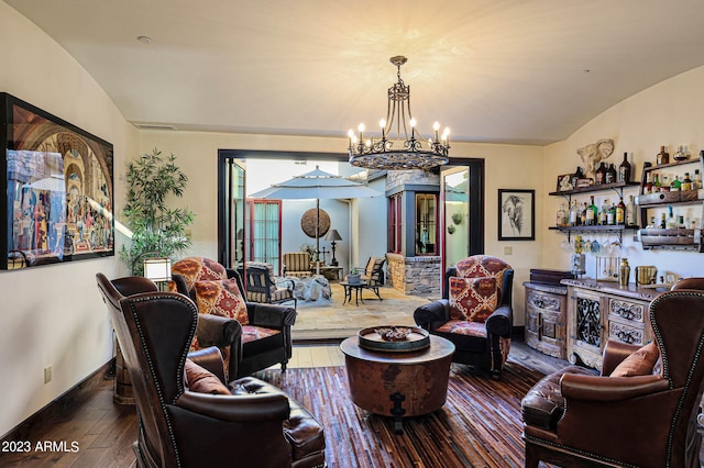 living room featuring an inviting chandelier, lofted ceiling, and hardwood / wood-style floors