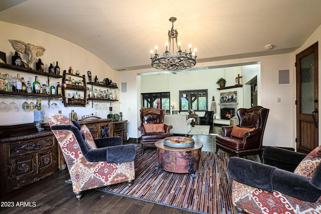 living room featuring vaulted ceiling, bar area, a chandelier, and hardwood / wood-style floors