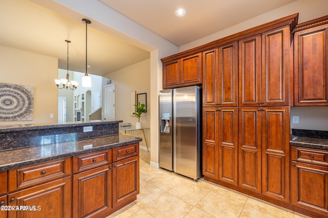 kitchen featuring an inviting chandelier, light tile patterned floors, dark stone counters, and stainless steel fridge with ice dispenser