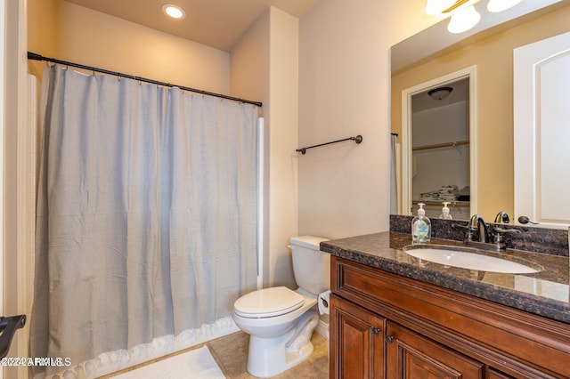 bathroom with toilet, a shower with curtain, vanity, and tile patterned floors