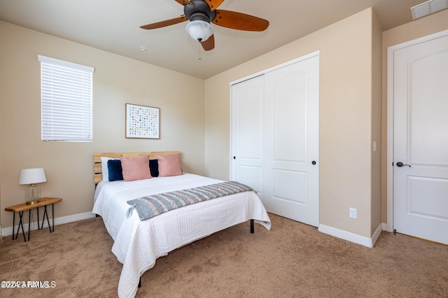 bedroom with a closet, ceiling fan, and light colored carpet