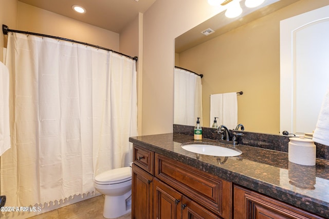 bathroom featuring toilet, walk in shower, vanity, and tile patterned flooring