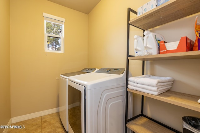 washroom featuring light tile patterned flooring and washer and dryer