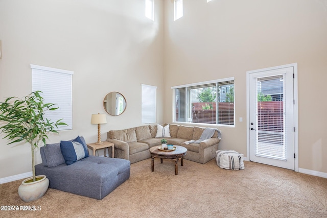 carpeted living room featuring a towering ceiling