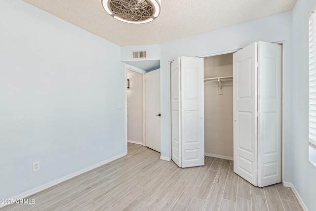 4845 W Evans Dr, Glendale, AZ 85306 - unfurnished bedroom featuring light wood-style floors, a textured ceiling, and a closet