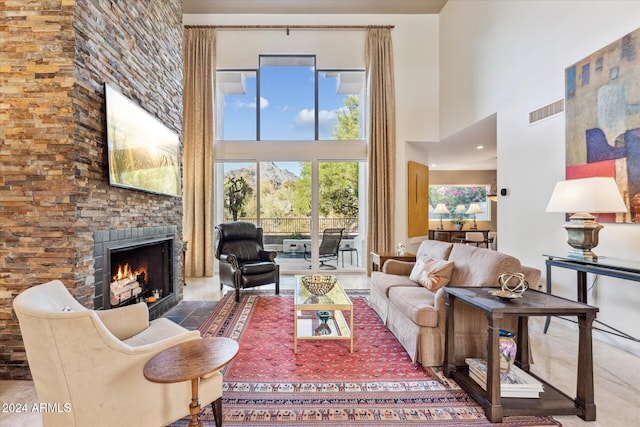 living room featuring a high ceiling and a large fireplace