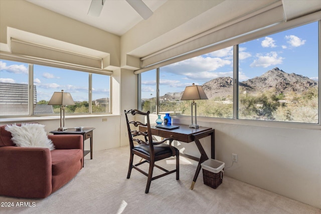 office space featuring a mountain view, light colored carpet, and ceiling fan