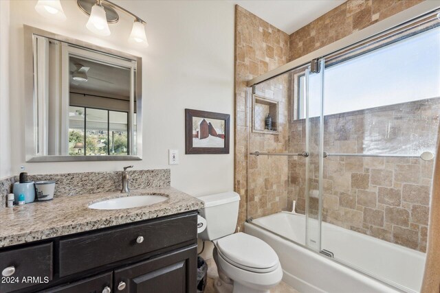 full bathroom featuring vanity, a healthy amount of sunlight, shower / bath combination with glass door, and toilet