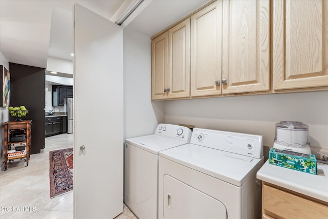 laundry area featuring washer and dryer and cabinets