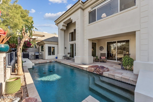 view of pool featuring central AC, grilling area, an outdoor kitchen, and a patio area