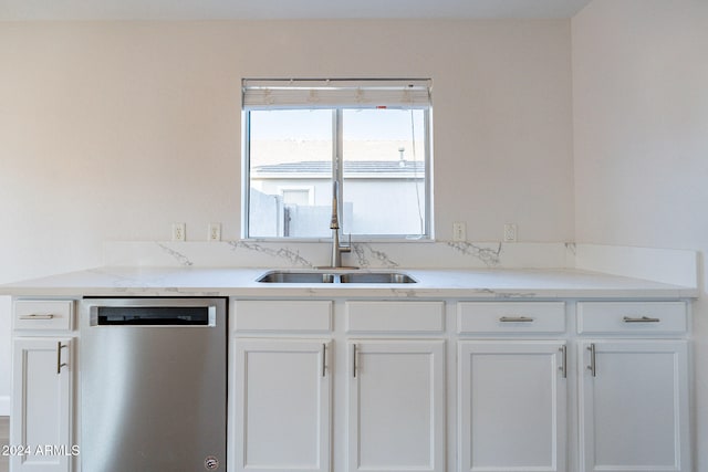 kitchen with white cabinets, light stone counters, sink, and stainless steel dishwasher