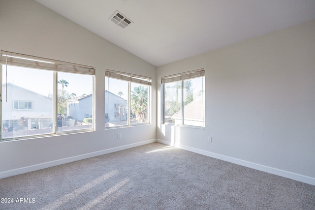 spare room with lofted ceiling and light carpet