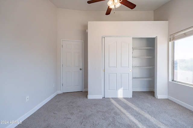 unfurnished bedroom with ceiling fan, a closet, and light carpet