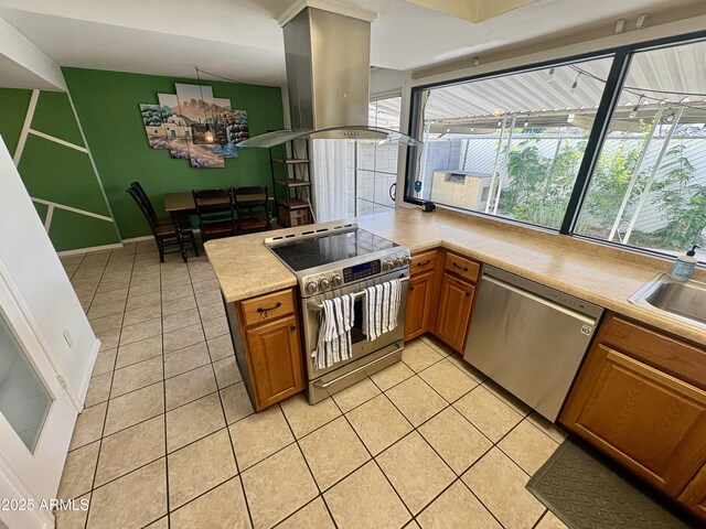 kitchen featuring kitchen peninsula, island exhaust hood, sink, and stainless steel fridge