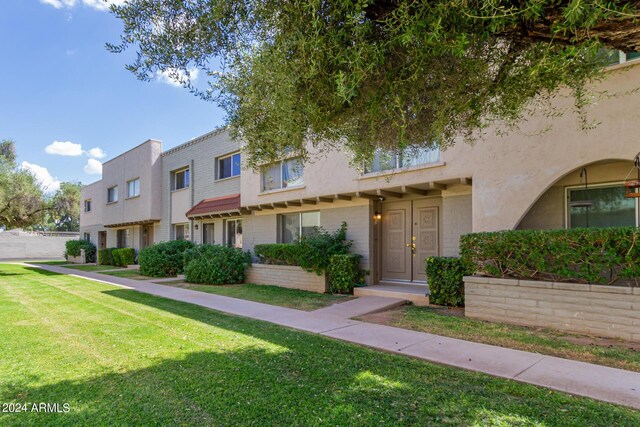 multi unit property featuring a front lawn