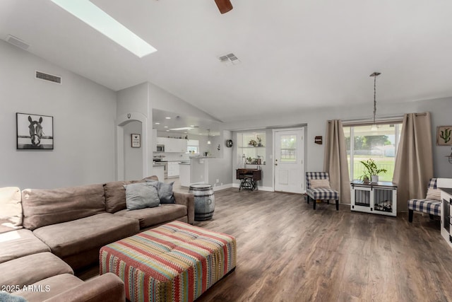 living area with vaulted ceiling with skylight, wood finished floors, and visible vents