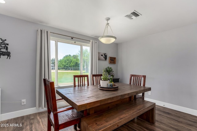 dining space with wood finished floors, visible vents, and baseboards