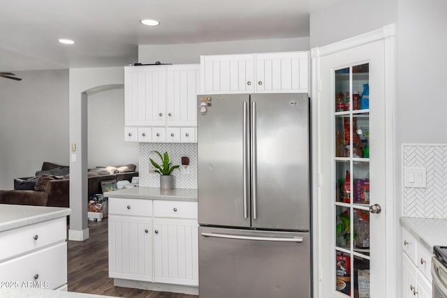 kitchen featuring white cabinets, stainless steel appliances, dark wood-style flooring, tasteful backsplash, and light countertops
