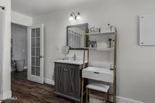bathroom with baseboards, wood finished floors, and vanity