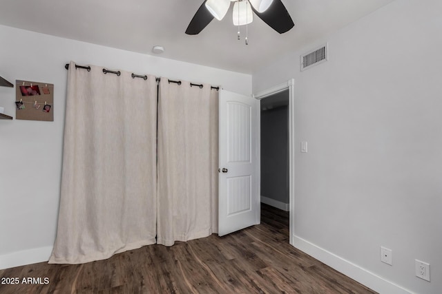 unfurnished bedroom with ceiling fan, baseboards, wood finished floors, and visible vents