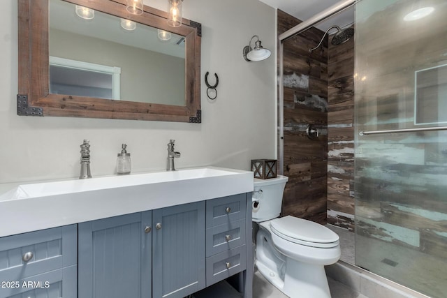 bathroom featuring a shower stall, toilet, and vanity
