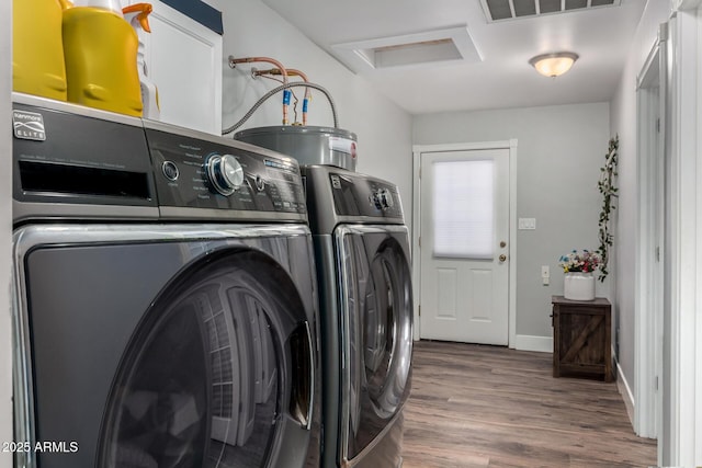 laundry area with laundry area, wood finished floors, visible vents, baseboards, and separate washer and dryer