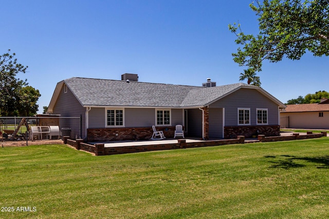 rear view of property with brick siding, a lawn, and a chimney
