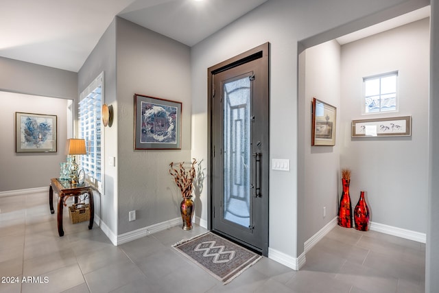 tiled entrance foyer featuring a healthy amount of sunlight