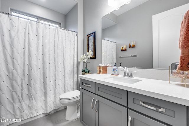 bathroom with tile patterned flooring, vanity, and toilet