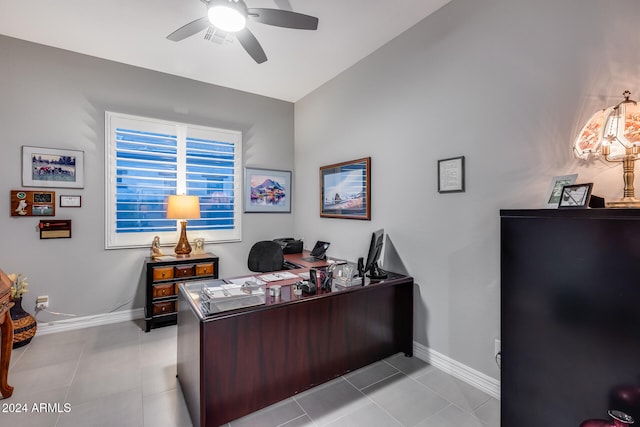 home office featuring ceiling fan, light tile patterned floors, and vaulted ceiling