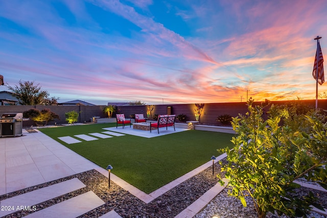 yard at dusk featuring an outdoor living space and a patio area