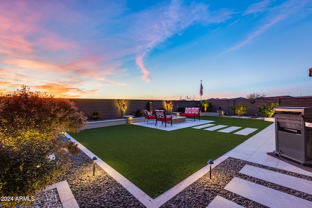 yard at dusk with a patio area and an outdoor living space with a fire pit