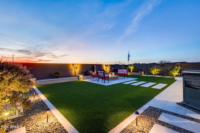 yard at dusk featuring a patio area and an outdoor hangout area