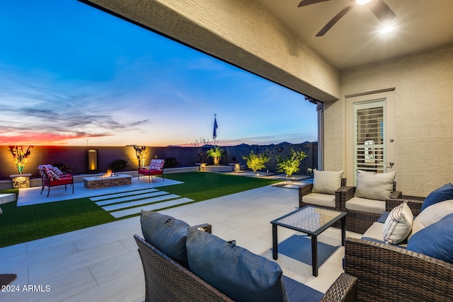 patio terrace at dusk featuring a mountain view and an outdoor fire pit