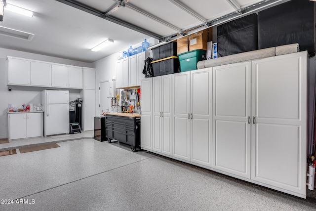 garage featuring a workshop area and white refrigerator