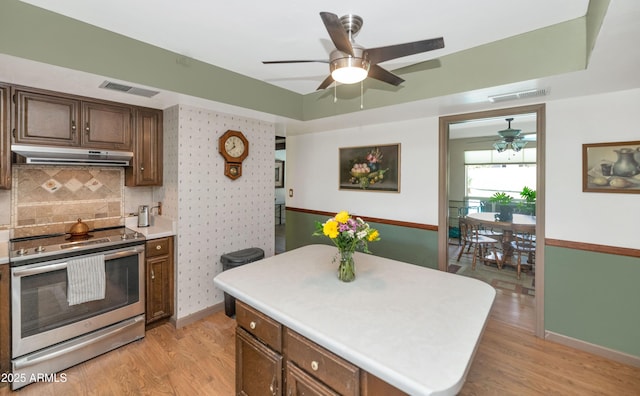 1298 E Buffalo St, Chandler, AZ 85225 - kitchen featuring stainless steel electric range, under cabinet range hood, light wood finished floors, ceiling fan, and light countertops