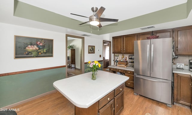 1298 E Buffalo St, Chandler, AZ 85225 - kitchen with freestanding refrigerator, light countertops, ceiling fan, light wood-style floors, and a center island