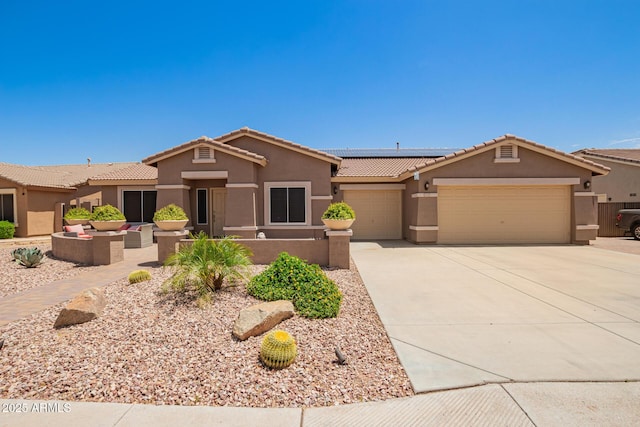 view of front of house with a garage, solar panels, a tile roof, and stucco siding