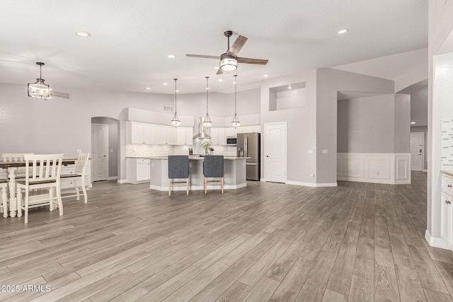 unfurnished living room featuring recessed lighting, a ceiling fan, and light wood-type flooring
