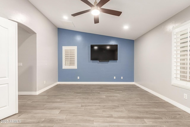 unfurnished room featuring a ceiling fan, light wood finished floors, and lofted ceiling