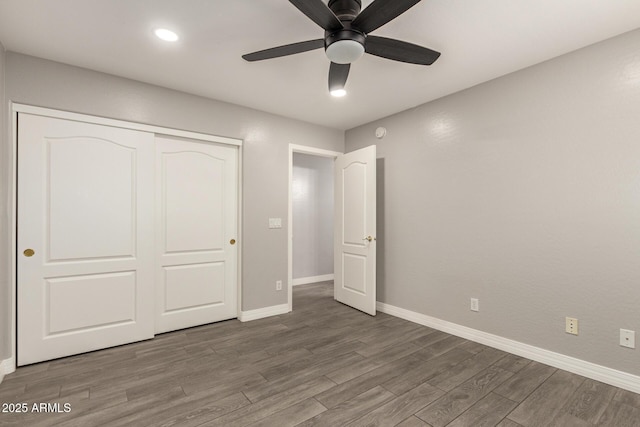 unfurnished bedroom featuring a ceiling fan, baseboards, wood finished floors, and a closet