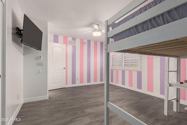 unfurnished bedroom featuring baseboards, ceiling fan, wallpapered walls, and wood finished floors