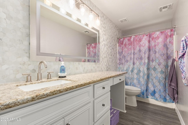 full bath featuring visible vents, wood finished floors, toilet, and vanity