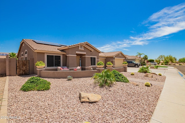 single story home featuring stucco siding, a gate, roof mounted solar panels, a fenced front yard, and a tile roof