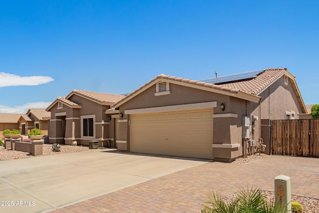 view of front of home featuring an attached garage, driveway, a tile roof, and stucco siding